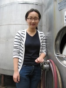 Vanilla Peng alongside stainless steel tanks that will soon be full of wine.