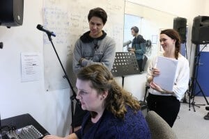 Guided by Julia Deans (right), Katlyn Harrison and Cleavelin Manaenae-Cook write vocal parts for one of the singer’s tracks.