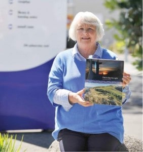  History in the writing - Co-author Jean Johnson with a copy of ‘First to See the Light’. Photo credit: Gisborne Herald.