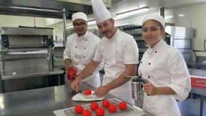 Acclaimed for his patisserie prowess, chef tutor Korey Field (centre) works with level 3 cookery students Vikram Singn and Ashlee McNabb on plating the dessert.    